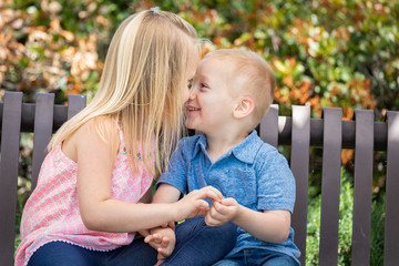 Fototapeta premium Young Sister and Brother Having Fun On The Bench At The Park
