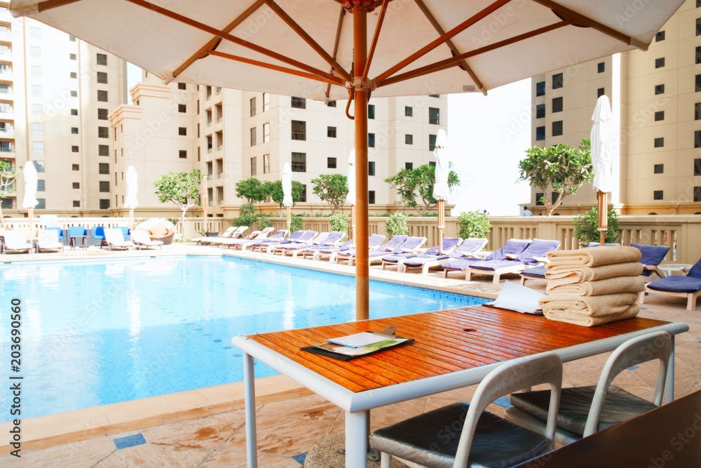 Aufkleber Stack of clean towel on wooden table near pool for service customer
