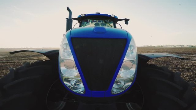 Blue tractor close-up against the sky
