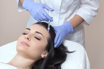 Procedure of mesotherapy. The doctor cosmetologist makes the procedure of mesotherapy in woman's head. Strengthen hair and their growth.