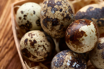 Obraz premium Quail eggs in a box on a rustic wooden background, top view, selective focus.