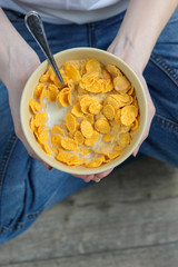 corn flakes in a bowl in hands