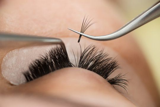 Fototapeta The master builds up large colored eyelashes to the client. Preparation for beauty photography. Creating an image.