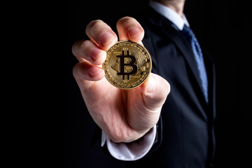 Fototapeta na wymiar Bitcoin cryptocurrency coin held out by a man in a suit
