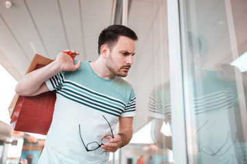 Attractive man standing in front of shop window