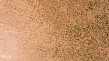 Aerial photo over ploughed dirt field. ground field view background 