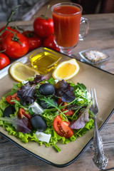 Salad diet for weight correction from the leaves of Lollo Rosso lettuce, watercress salad and other green herbs with tomatoes, olives and fitaki. Close up.