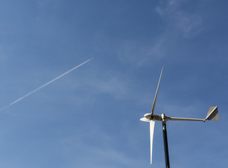 Wind turbine isolated on blue sky and clouds