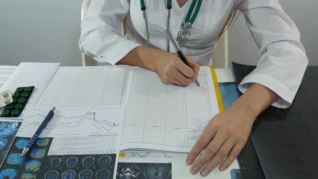 woman doctor writes data to a journal