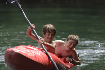 Dos Hermanos Disfrutando del Kayak en Vacaciones de Verano.  - obrazy, fototapety, plakaty