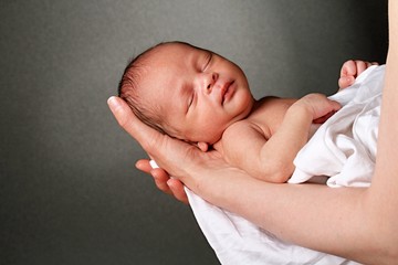 baby in mothers arms stock photo