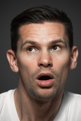 Obraz premium Close-up portrait of surprised caucasian man on gray background