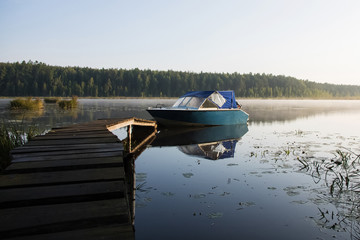 boat at the pier of the forest lake