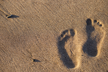 Human footprints on the sand beach. Travel vacations concept.