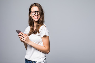 Side view of woman in glasses and white shirt making selfie on phone isolated gray background