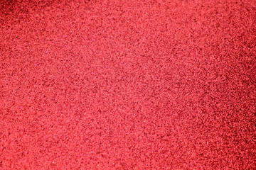 Red glittering background with blur effect.