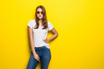 Beauty portrait of a happy young woman in sunglasses over yellow background. Beauty, fashion.