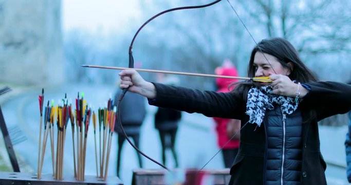 Woman focused on hitting target with arrow. Woman archer shoots with a bow in 4K. Tourist woman practicing archery.2