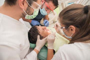 Boy with perfect teeth at the dentist doing check up with the clininc at the background - oral hygiene health care concept