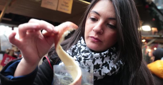 Young woman eating traditional hungarian cinnamon chimney cake sweet dessert