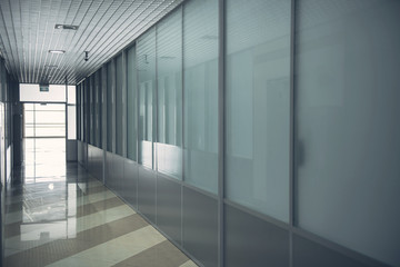 Design of long hallway with glass walls and with window at end of it
