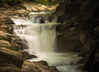 Naklejka na ściany i meble waterfall with long exposure and rocky mountain