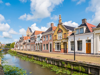 Fototapeta na wymiar Canal and tower of church in old town of Bolsward, Friesland, Netherlands