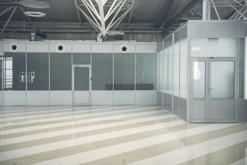 Two grey doors locating in wide hall with striped floor