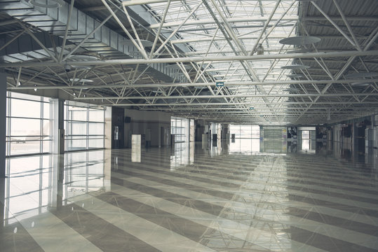 Interior of huge bright empty building inside with high ceiling and wide windows