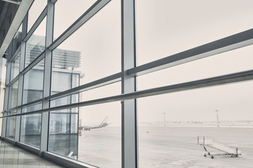 Close up wide window of contemporary building. Aircraft waiting for flight outside