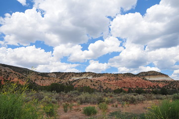 Southwestern red rock mesa in New Mexico, with big puffy clouds
