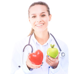 Beautiful smiling female doctor holding red heart and green apple. Woman doctor