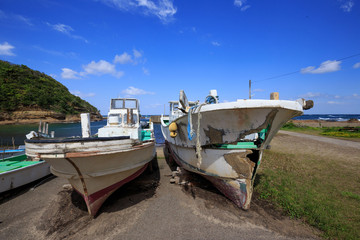 Fototapeta na wymiar Old Japanese fishing boats sit dockside in a state of disrepair