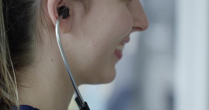 Nurse smiling while using stethoscope on patient - close up on happy nurse