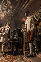 Actors in Steam punk masks and antique costumes indoor.