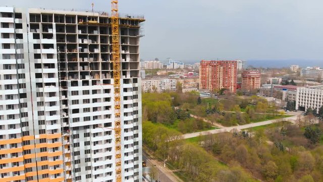 Construction site with a bird's eye in a megacity. Video shooting with drone. New house in a new residential complex. Flying over the construction site. New house next door in the city. 4K.