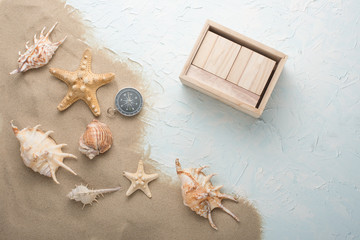 Shells in the sand on a blue texture, with an empty calendar