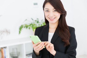 Fototapeta premium スマートフォンを見る女性 ビジネス