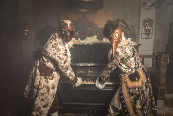 Actors in Steam punk masks and antique costumes indoor.