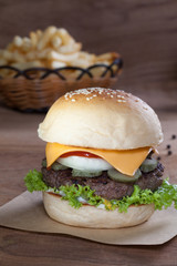 Close up of beef burger with cheese on wood table.