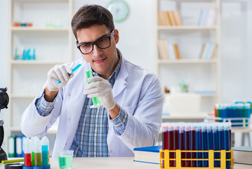 Young chemist student working in lab on chemicals