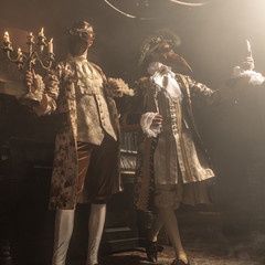 Actors in Steam punk masks and antique costumes indoor.