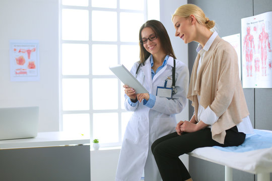 Doctor and patient discussing something while sitting at the table . Medicine and health care concept