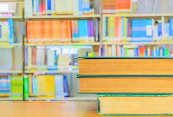 old book red - green. heap are interior library school on wooden table and blurry bookshelves background. education learning concept with copy space add text