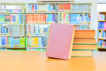 old book red - green. heap are interior library school on wooden table and blurry bookshelves background. education learning concept with copy space add text