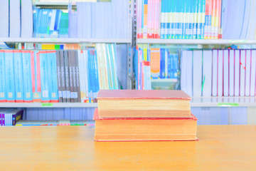 old book red - green. heap are interior library school on wooden table and blurry bookshelves background. education learning concept with copy space add text