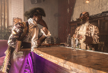 Actors in Steam punk masks and antique costumes indoor.