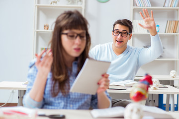 Two medical students studying in classroom