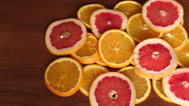 Sliced citrus fruits, oranges and grapefruit, on wooden table, close-up. Abstract background with citrus-fruit of orange slices. Close-up. Sliced orange background.