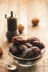 Dry dates in a bowl on a vintage or rustic table top wood background